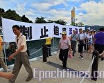 “制止迫害法轮功”的横幅贴近湖岸边展示著，许多上岸的广东旅游团经过和注目。（摄影：宋碧龙／大纪元）
