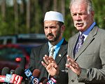 在教会的草坪前，特里‧琼斯牧师（图右）9月11日表示，他取消星期六焚烧《可兰经》的计划是因为他和穆斯林领袖就转移在纽约修建伊斯兰文化中心和清真寺的地点问题上达成了协议。（PAUL J. RICHARDS/AFP/Getty Images)
