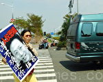 楊松座車(墨綠色車)面臨法輪功學員舉出的「楊松人權惡棍 台灣不歡迎你」的看板。（攝影：李曜宇／大紀元）