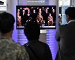 韩国民众在首尔火车站看电视，电视画面上前排右一为金正日Kim Jong-Il，前排左二为他的小儿子金正银Kim Jong-Un。(图/JUNG YEON-JE/AFP/Getty Images)