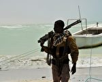 一位索马里海盗扛着武器。（AFP）