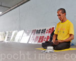 蔡永水在新加坡魚尾獅風景點講述法輪功被迫害真相，長達11年，風雨無阻，每天都拿著揭露中共迫害法輪功的展板去那裡打坐。（攝影：明國／大紀元）