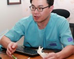 韩国JW整形外科医院专门院长崔凤均（Bong-Kyoon Choi,M.D.）日前在接受大纪元采访时，手持颌骨模型举例说明面部整形的原理。（摄影：全宇/大纪元）