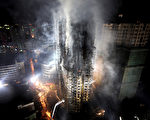 2010年11月15日，上海膠州路教師公寓發生大火，消防部門對大火幾乎無能為力。上海市民質疑：防火演習時作秀的先進消防車都到哪裡去了？圖為大火現場。（AFP）