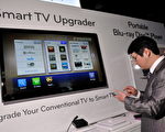 韓國LG公司提供機頂盒，使電視機也可以上網。圖為2011年1月6日在內華達州拉斯維加斯希爾頓酒店舉行的2011年國際消費電子展上，參觀者用智能手機升級LG- 600智能電視機機頂盒。(Photo by David Becker/Getty Images)
