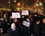 2011年1月14日，在巴黎突尼西亚大使馆附近，人们高举著标语牌庆祝突尼西亚总统阿里离开，总理接管担任临时总统。（PIERRE VERDY /AFP）
