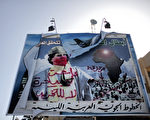 2011年3月1日，在利比亞東部城市班加西機場外的一幅卡紮菲的巨型廣告牌被損毀。(Photo credit should read MARCO LONGARI/AFP/Getty Images)（Staff: MARCO LONGARI / 2011 AFP）