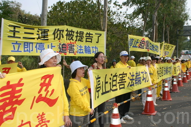 台南市議員曾秀娟(左3)聲援法輪功,一起拉橫幅對王三運大聲呼口號。(賴友容/大紀元)