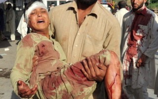 5月13日巴基斯坦西北部夏伯卡達堡的一處軍事訓練基地發生兩起自殺炸彈攻擊事件，造成至少80人死亡，該國塔利班分子聲稱對此事件負責。圖為一名巴基斯坦男子將爆炸受傷者送到醫院。（AFP）