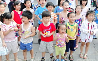 30位小朋友互別紫絲帶，傳愛弱勢兒童，響應全球反家暴運動。（攝影：黃玉燕/ 大紀元）