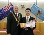 二零一一年六月二十九日晚七點,澳洲悉尼布萊克鎮(Blacktown City)市政廳為當地節日大遊行獲獎團體舉辦頒獎儀式,法輪功學員組成的天國樂團獲得樂團冠軍。圖為布萊克鎮市長(左)向法輪功團體代表頒獎。