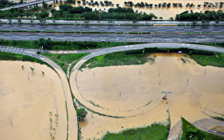 2011年7月28日，鳥瞰韓國漢城受暴雨襲擊漢江水域夾雜泥濘淹沒道路。（圖片來源：KIM JAE-HWAN／AFP）