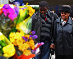 伯明翰有三位居民为保护商店，被暴徒用汽车撞死。图为民众为死者献花。（Staff：Jeff J Mitchell / 2011 Getty Images）