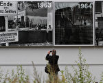 2011年8月13日，一名男子在伯瑙爾街的柏林牆上展示的歷史圖片前拍照。（ MICHELE TANTUSSI / AFP ImageForum）