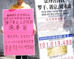 近日在中共駐韓大使館前舉牌抗議的楊女士時說，媽媽朱春菊被中共公安非法抓捕，當局威脅說要重判7至11年，罪名是「故意毀壞人民幣」。（攝影：全宇/大紀元）