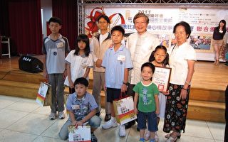 2011年9月4日赖沈秀圭(右)与得奖孙女、孙子、文化局饶嘉博局长(后排右2)及得奖同学及老师合照。（摄影：李撷璎／大纪元）