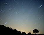 科学家认为，在地球降温后硬化，形成岩石之后，这些地幔上可及的黄金和其他耀眼的稀有金属是从外太空掉到地球上的。图为，2010年8月13日，一颗流星划过西班牙南部的天空。 (Jorge Guerrero/AFP/Getty Images)