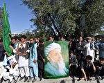 阿富汗前总统、负责政府与塔利班（Taliban）和平谈判的官员拉巴尼（Burhanuddin Rabbani）20日在住所遇袭身亡。图为支持者21日拿着他的照片在其住所外聚集。（AFP）