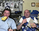 欧洲宇航局的宇航员Andre Kuipers（右），以及美国宇航局的宇航员Michael Foale，在国际太空站上的无重力状态下，吃着到处飞的起司早餐。（摄影：ESA/via Getty Images）