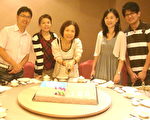 黄姓妇人在来自台北的女儿与女婿陪伴下，快乐切国庆蛋糕！（摄影：徐乃义／大纪元）