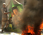 曾绿遍全国每一个角落的“绿宝书”的下场显而易见：不是被焚烧就是被撕毁。这似乎也在预示著卡扎菲未来的命运。 图为焚烧卡札菲画像。（Staff: PATRICK BAZ / 2011 AFP）