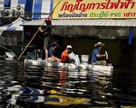 2011年10月25日，曼谷的Rangsit区，洪水淹没街道民众以小船载运受困民众(NICOLAS ASFOURI/AFP/Getty Images)