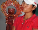 Yani Tseng of Taiwan kisses the trophy after her victory in the Sunrise LPGA Taiwan Championship golf tournament in Yangmei, northern Taoyuan county on October 23, 2011.   AFP PHOTO / Sam YEH (Photo credit should read SAM YEH/AFP/Getty Images)（Staff: SAM YEH / 2011 AFP）