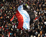 11月25日,抗议者扛着埃及国旗,在首都开罗的塔利尔广场(Tahrir Square)举行大集会,抗议军政府。(Peter Macdiarmid/Getty Images)