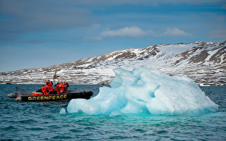 北极的海上冰层过去40-50年来一直在消融。图为探测家乘坐的小船行经北极新奥尔松一处已融化的冰山。（STF: MARTIN BUREAU / AFP ImageForum）