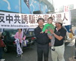 受迫害台商賴添鎮(左)與其幼子一同參加反害遊行。 （攝影：蘇泰安／大紀元）