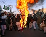 2011年11月29日，巴基斯坦逊尼派（Sunni Tehreek）分子在拉瓦尔品第（Rawalpindi）焚烧美国国旗抗议北约11月26日在巴基斯坦与阿富汗边界的空袭事件。（AFP PHOTO/Farooq NAEEM）