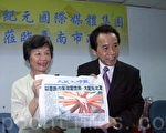 互赠纪念品，大纪元台湾分社社长曹慧玲（左）以8国发行报纸回赠台南市副市长林钦荣。（摄影：赖友容／大纪元）