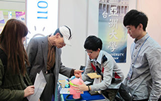 台湾亚洲大学创意设计学院学生1日在韩国首尔国际会议暨展示中心（COEX）向首尔国际发明展评审们讲解研发作品头部按摩器的动机与功能。（亚洲大学提供）