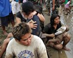 2011年12月17日，菲律宾官员表示，台风瓦西（Washi）带来豪雨，造成南部暴洪成灾，死亡人数今天激增至180人，且有近4百人失踪。图为伊利甘市两名妇女怀里抱着她们在暴洪中丧生的子女（AFP PHOTO/Cherryl Vergeire）