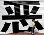 陆丰乌坎村已被当局包围封锁10天。日前，村民召开会决定，将在12月21日突破封锁去市政府游行示威。图为，一小女孩在一横幅下玩耍。(MARK RALSTON/AFP/Getty Images)