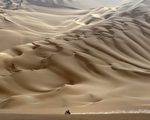 一辆越野摩托车在沙漠中奔驰 （PHILIPPE DESMAZES / AFP）