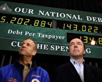 2012年1月8日在新罕布什尔州的埃克塞特(Exeter)，美国共和党总统候选人、前马萨诸塞州州长罗姆尼（Mitt Romney）的支持者在一个集会上，后面是一个国债时钟( national debt clock )。(Photo by Justin Sullivan/Getty Images)