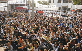 2011年12月11日，广东乌坎村五千多村民拿起棍棒、农具把守村口，与一千名欲夺回乌坎村控制权的警察对峙。（AFP）