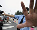 中國的新聞自由在世界排名中幾乎敬陪末座。圖為2008年京奧期間一位中國警察在奧運會體育館主會場附近禁止一位英國記者對警戒線後的西藏抗議者拍照（JEWEL SAMAD/AFP/Getty Images）