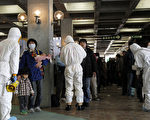 圖為福島電廠反應爐在2011年3月發生爆炸造成輻射外洩後，穿上防輻衣的人員正為撤離災區的民眾進行輻射汙染檢測。（攝影：KEN SHIMIZU/AFP/Getty Images）