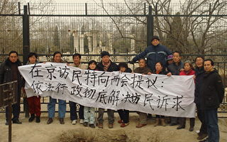 上海民众打着“在京访民特向两会提议：依法行政彻底解决访民诉求”横幅。（上海访民提供）