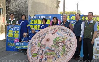 7日曾文忠老師現場彩繪超大紙傘，穿著客家傳統藍衫的高雄市副市長劉世芳號召大家上網投票，唯一支持美濃。（攝影: 黃振茂 / 大紀元）