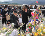 2012年3月11日，宮城縣石卷市，民眾為罹難者祝禱。（KAZUHIRO NOGI/AFP）