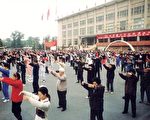 1999年7.20之前，每天清晨，北京的大小公园、绿地、广场，法轮功学员晨炼的身影到处可见。图为北京千人炼功点，千名法轮功学员在“首都体育馆”（海淀区白石桥）前的清晨集体炼功。（1998年秋）