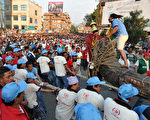 尼泊爾加德滿都慶祝戰車節，民眾4月25日拖拉著巨型戰車上街遊行，祈求風調雨順、穀物豐收及繁榮好運。(Prakash MATHEMA/AFP)