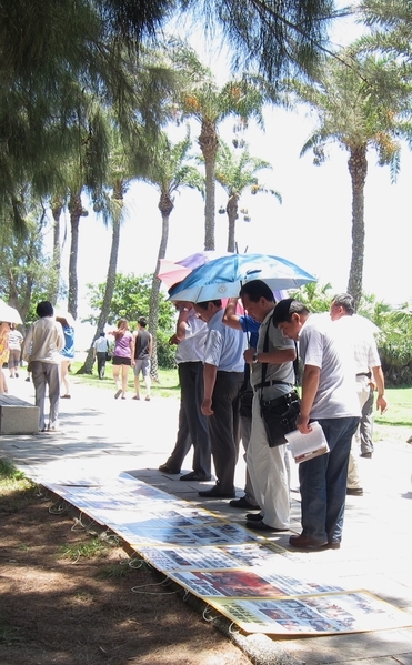 許多中國遊客看到現場展示的真相圖片及資料,都停下腳步仔細閱讀,並熱烈討論。(攝影:簡惠敏 /大紀元) 許多中國遊客看到現場展示的真相圖片及資料,都停下腳步仔細閱讀,並熱烈討論。(攝影:簡惠敏 /大紀元)