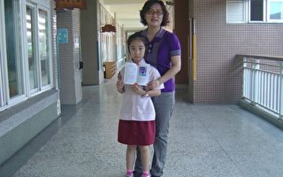 北园国小江姿满老师与小二女儿开心拿着$$%妹妹"珍的照片。  （摄影：苏泰安／大纪元）