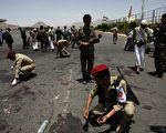 2012年05月21日，1名也門士兵在軍隊隊伍中引爆夾藏在軍服內的爆裂物，造成96名士兵死亡。圖為也門軍警在事發現場收集證據。（MOHAMMED HUWAIS / AFP）