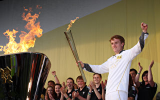 伦敦奥运火炬传递第9天，16岁的Kyle Thomson点燃奥运火炬庆典大釜。（图片来源：Getty images）