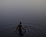 印度新德里，一位印度教徒在亚穆纳河净身。摄于2012年5月31日(Andrew Caballero-Reynolds / AFP)